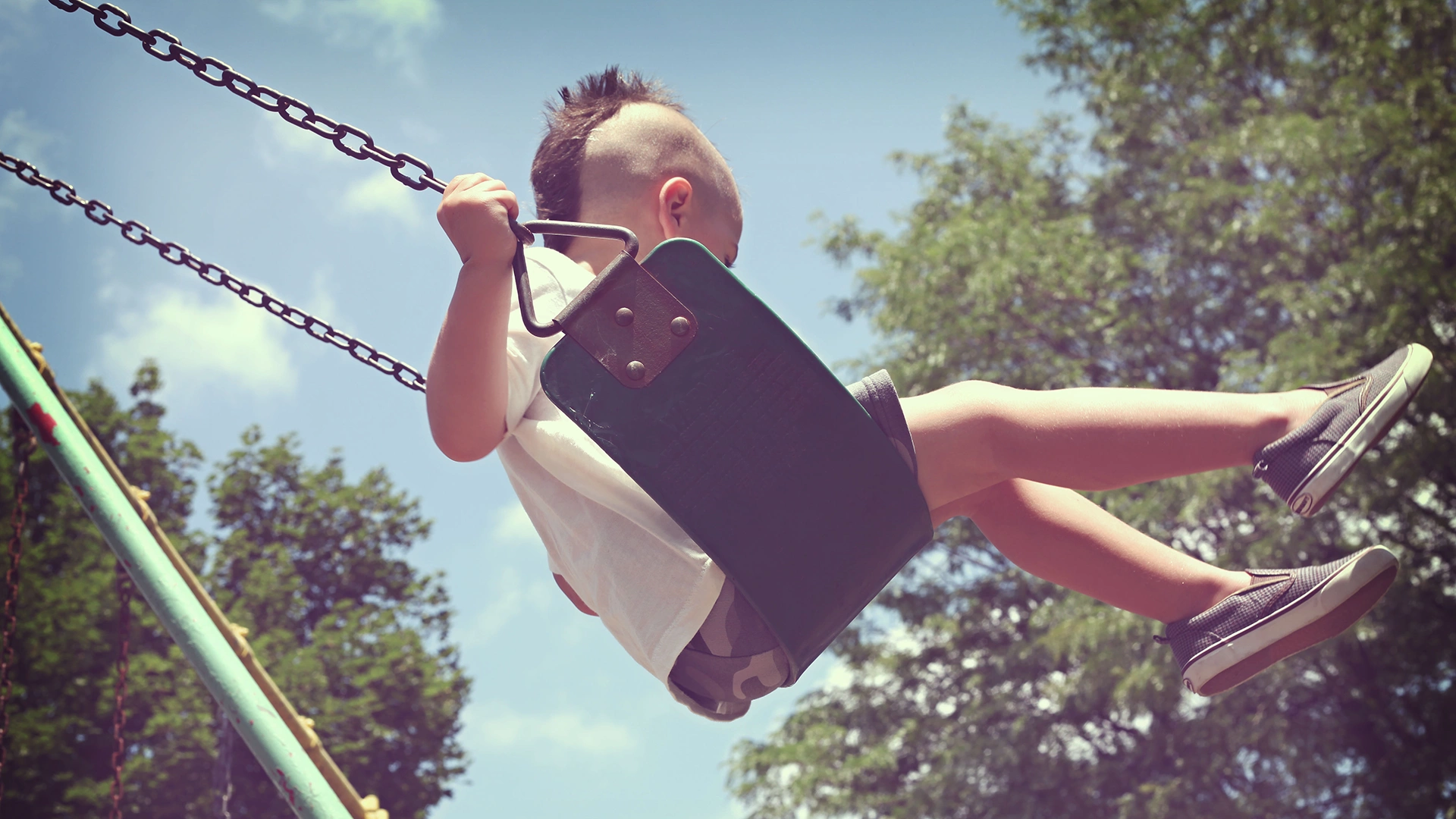 Young boy swinging on a swing